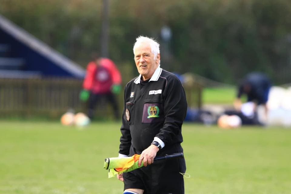Senior referee smiling on the touchline
