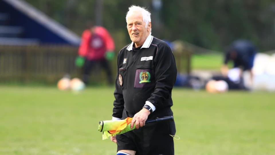 An experienced assistant referee on the touchline at a grassroots match